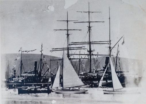Knysna Yacht Club yachts and pulling boat pass the ss Agnar, ss Ingerid, and one of the whalers from Plettenberg Bay at Thesens Wharf, early 20th Century 