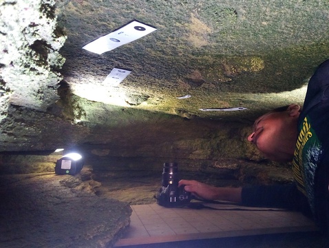 Charles W. Helm, a discoverer of the fossil hominin footprint tracksite near Knysna, South Africa, works in the confined space at the rear of the cave. Image: Linda Helm